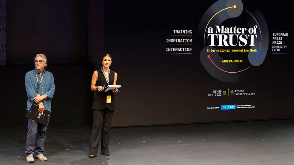 Δύο μέλη του Ιδρύματος, στέκονται στη σκηνή για τη Διεθνή Εβδομάδα Δημοσιογραφίας Ι A matter of trust International Journalism Week